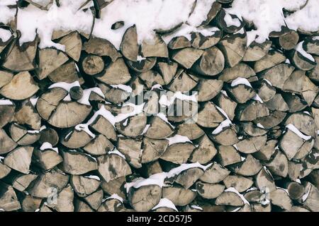 Das gehackte Brennholz auf dem Stapel im Schnee. Vorderansicht Stockfoto