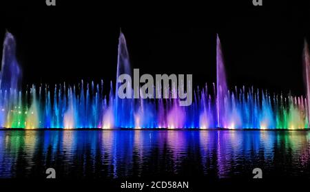 Nacht Laser-Brunnen zeigen, auf dem Ufer des Roshen, der ukrainischen Stadt Winniza.Musikbrunnen mit Laser-Animationen.Musikbrunnen Roshen in Winniza, Ukraine.Abendshow Roshen Brunnen. Stockfoto