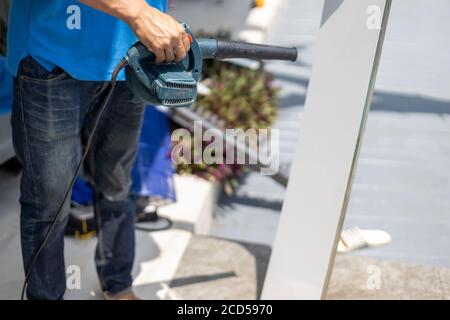 Meister putzen die Klimaanlage in einem tropischen Hotel. Stockfoto