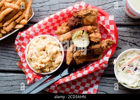 Gebratenes Huhn mit mac und Käse, Krautsalmen und Pommes auf Holztisch Stockfoto