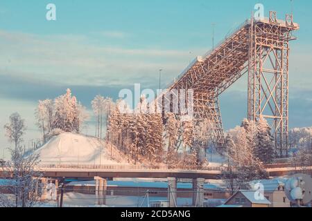 Ein Skisprungturm in einem verschneiten Wald, alle mit Frost und Schnee bedeckt Stockfoto