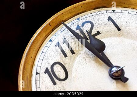 Alte Vintage-Uhr zeigt 2 Minuten bis 12 Uhr auf schwarzem Hintergrund. Silvester- oder Countdown-Konzept. Stockfoto