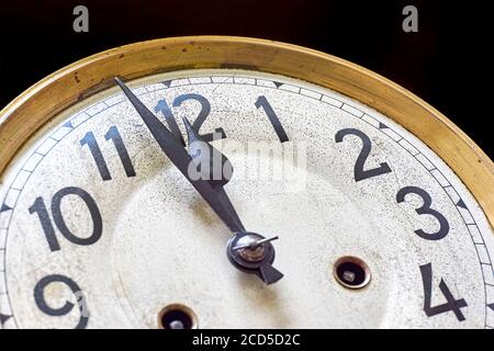 Alte Vintage-Uhr zeigt 2 Minuten bis 12 Uhr auf schwarzem Hintergrund. Silvester- oder Countdown-Konzept. Stockfoto