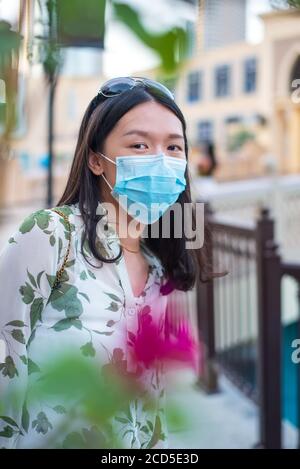 Asiatische Frau trägt chirurgische Gesichtsmaske im Außenbereich eines Einkaufszentrums in Dubai. Reisen und Freizeit neue Normalität nach Coronavirus Covid-19 Pandemie Stockfoto