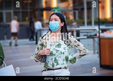 Asiatische Frau trägt chirurgische Gesichtsmaske im Außenbereich eines Einkaufszentrums in Dubai. Reisen und Freizeit neue Normalität nach Coronavirus Covid-19 Pandemie Stockfoto