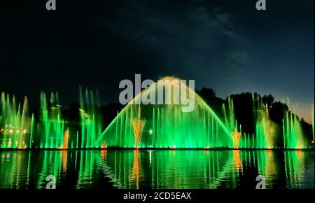 Nacht Laser-Brunnen zeigen, auf dem Ufer des Roshen, der ukrainischen Stadt Winniza.Musikbrunnen mit Laser-Animationen.Musikbrunnen Roshen in Winniza, Ukraine.Abendshow Roshen Brunnen. Stockfoto