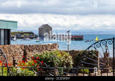 Blick über einen Garten in Richtung Elie Hafen an einem Sommertag. Stockfoto