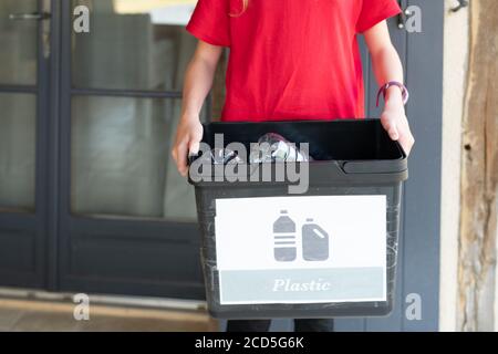 Kind hält Recycling-Eimer voller Plastikflaschen Stockfoto