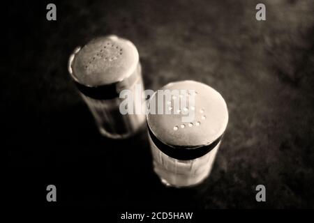 Nahaufnahme von Pfeffer und Salz Shaker in schwarz und Weiß Stockfoto
