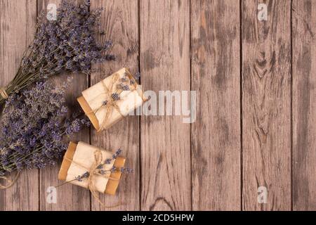 Bars von natürlichen handgemachten Seife mit Lavendel-Extrakt und Lavendelblüten auf natürlichem Holzhintergrund mit Copyspace. Home Spa-Behandlungen. Natürlich Stockfoto