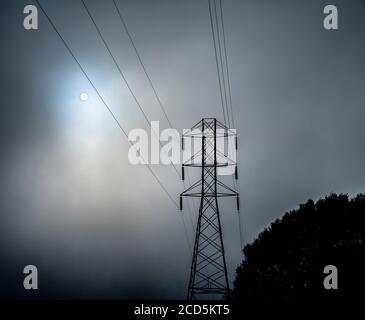 Blick auf Hügel, Stromleitungen und Nebel Stockfoto