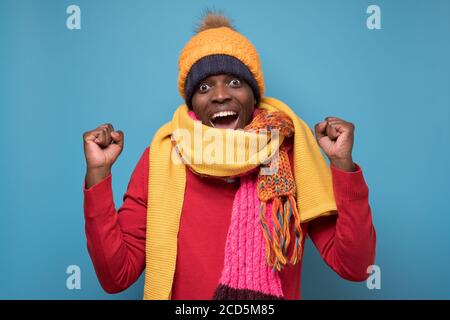 Mann trägt warmen Schal und Hut klatschende Fäuste tun Sieger Geste Ja sagen Stockfoto