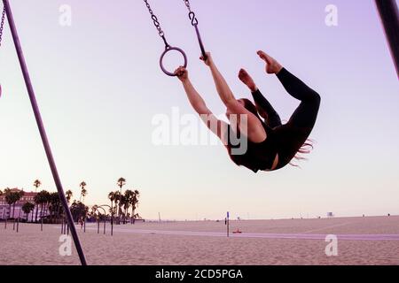 Weibliche flugforscherin acrobat am Strand in der Nähe von Santa Monica Pier, Santa Monica, Kalifornien, USA Stockfoto