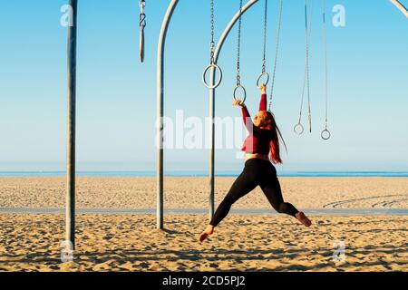 Weibliche flugforscherin acrobat am Strand in der Nähe von Santa Monica Pier, Santa Monica, Kalifornien, USA Stockfoto