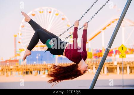 Weibliche flugakrobatin auf Schaukel am Strand in der Nähe von Santa Monica Pier, Santa Monica, Kalifornien, USA Stockfoto