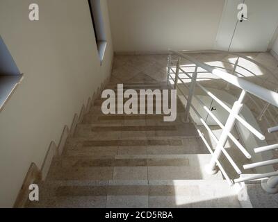 Weißer Korridor mit Marmorstufen, die zu den Türen führen. Stockfoto
