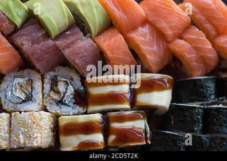 Maki und Brötchen mit Thunfisch, Lachs und Avocado. Typisch japanisches Essen. Sushi-Set. Stockfoto