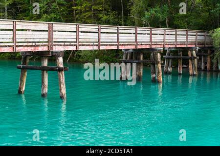 Brücke über türkisblaues Wasser von Plansee in Österreich, Sommerabend Stockfoto