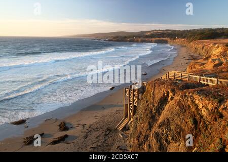 Pacific Sunset Warmherzigkeit - der Sonnenuntergang am Strand lädt Besucher ein, die Treppen hinunter zu steigen. Black Point Beach, Sonoma Coast, Kalifornien, USA Stockfoto
