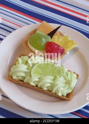Limettenkuchen und ein Früchtettedessert Stockfoto