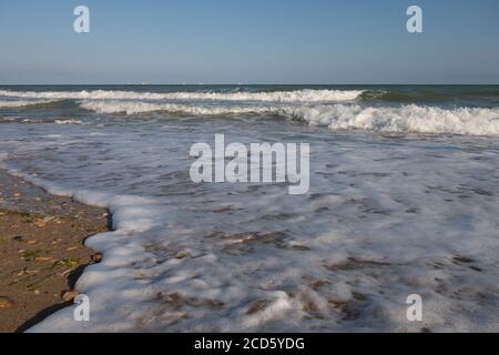 Schäumende Küste. Tidalbohrung. Strand. Langweilige See. Stockfoto