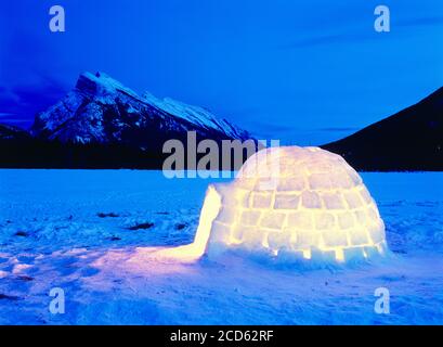 Glühendes Iglu bei Nacht und Mount Rundle im Hintergrund im Winter, Vermillion Lakes, Banff National Park, Alberta, Kanada Stockfoto