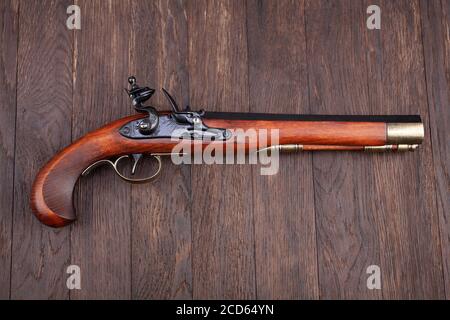Alte Retro-Muzzleloader-Feuerstock-Pistole auf Holzschreibtisch Stockfoto