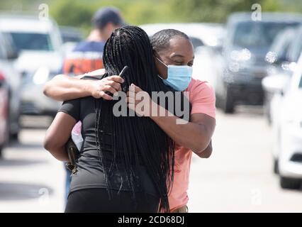 Austin, TX USA 26. August 2020: Dante Ferguson aus Beaumont begrüßt einen Freund in einem Evakuierungszentrum für Bewohner von Huricane Laura an der Küste von Ost-Texas und Südwest-Louisiana. Das Zentrum, auf der Rennstrecke Circuit of the Americas, war schnell mit Hunderten von Autos gefüllt. Laura wird erwartet, dass sie über Nacht als Sturm der Kategorie 4 landet und an der texanischen Küste und im Landesinneren verheerende Schäden anrichtet. Kredit: Bob Daemmrich/Alamy Live Nachrichten Stockfoto