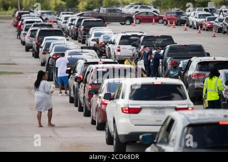 Austin, TX USA 26. August 2020: Hunderte von Autos aus dem Küstengebiet von Ost-Texas und dem Südwesten Louisianas warten in der Schlange vor einem Hurricane Laura Evakuierungszentrum, das von Austin-Beamten auf den Parkplätzen der Rennstrecke Circuit of the Americas eingerichtet wurde. Fahrer, die früh ankommen, erhalten Gutscheine für Hotelzimmer. Sobald diese ausgelaufen waren, wurden die Fahrer zu anderen Evakuierungszentren in Waco und Dallas geleitet. Laura wird voraussichtlich über Nacht als Sturm der Kategorie 4 landen und verheerende Schäden an der Küste von Texas und Louisiana und im Landesinneren anrichten. Kredit: Bob Daemmrich/Alamy Live Nachrichten Stockfoto