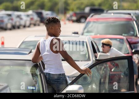 Austin, TX USA 26. August 2020: Hunderte von Autos aus dem Küstengebiet von Ost-Texas und dem Südwesten Louisianas warten in der Schlange vor einem Hurricane Laura Evakuierungszentrum, das von Austin-Beamten auf den Parkplätzen der Rennstrecke Circuit of the Americas eingerichtet wurde. Fahrer, die früh ankommen, erhalten Gutscheine für Hotelzimmer. Sobald diese ausgelaufen waren, wurden die Fahrer zu anderen Evakuierungszentren in Waco und Dallas geleitet. Laura wird voraussichtlich über Nacht als Sturm der Kategorie 4 landen und verheerende Schäden an der Küste von Texas und Louisiana und im Landesinneren anrichten. Kredit: Bob Daemmrich/Alamy Live Nachrichten Stockfoto