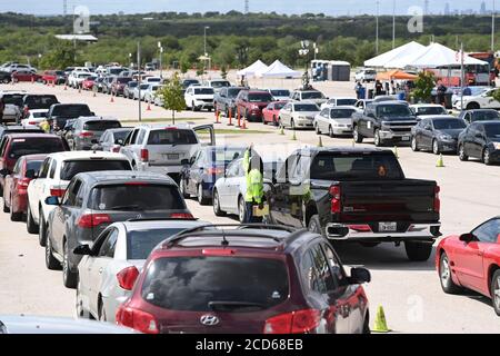 Austin, TX USA 26. August 2020: Hunderte von Autos aus dem Küstengebiet von Ost-Texas und dem Südwesten Louisianas warten in der Schlange vor einem Hurricane Laura Evakuierungszentrum, das von Austin-Beamten auf den Parkplätzen der Rennstrecke Circuit of the Americas eingerichtet wurde. Fahrer, die früh ankommen, erhalten Gutscheine für Hotelzimmer. Sobald diese ausgelaufen waren, wurden die Fahrer zu anderen Evakuierungszentren in Waco und Dallas geleitet. Laura wird voraussichtlich über Nacht als Sturm der Kategorie 4 landen und verheerende Schäden an der Küste von Texas und Louisiana und im Landesinneren anrichten. Kredit: Bob Daemmrich/Alamy Live Nachrichten Stockfoto