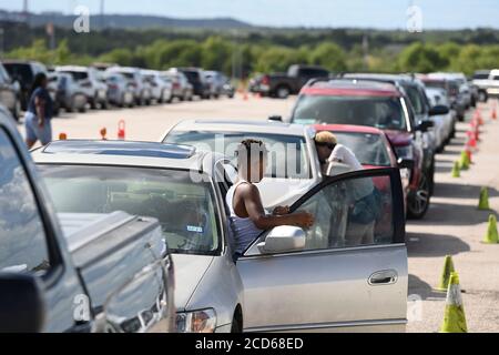 Austin, TX USA 26. August 2020: Hunderte von Autos aus dem Küstengebiet von Ost-Texas und dem Südwesten Louisianas warten in der Schlange vor einem Hurricane Laura Evakuierungszentrum, das von Austin-Beamten auf den Parkplätzen der Rennstrecke Circuit of the Americas eingerichtet wurde. Fahrer, die früh ankommen, erhalten Gutscheine für Hotelzimmer. Sobald diese ausgelaufen waren, wurden die Fahrer zu anderen Evakuierungszentren in Waco und Dallas geleitet. Laura wird voraussichtlich über Nacht als Sturm der Kategorie 4 landen und verheerende Schäden an der Küste von Texas und Louisiana und im Landesinneren anrichten. Kredit: Bob Daemmrich/Alamy Live Nachrichten Stockfoto