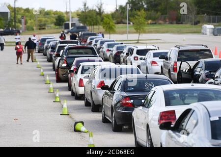 Austin, TX USA 26. August 2020: Hunderte von Autos aus dem Küstengebiet von Ost-Texas und dem Südwesten Louisianas warten in der Schlange vor einem Hurricane Laura Evakuierungszentrum, das von Austin-Beamten auf den Parkplätzen der Rennstrecke Circuit of the Americas eingerichtet wurde. Fahrer, die früh ankommen, erhalten Gutscheine für Hotelzimmer. Sobald diese ausgelaufen waren, wurden die Fahrer zu anderen Evakuierungszentren in Waco und Dallas geleitet. Laura wird voraussichtlich über Nacht als Sturm der Kategorie 4 landen und verheerende Schäden an der Küste von Texas und Louisiana und im Landesinneren anrichten. Kredit: Bob Daemmrich/Alamy Live Nachrichten Stockfoto