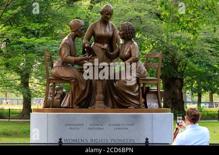 Eine Person nimmt ein Telefonfoto der Bronzestatue der 'Women’s Rights Pioneers' auf, einer Skulptur von Meredith Bergmann im Central Park, New York, NY. Stockfoto