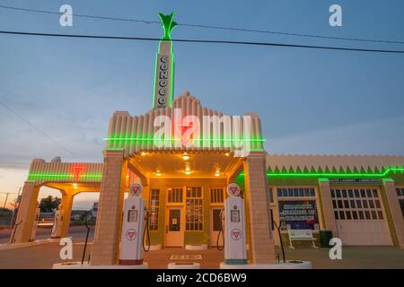 Shamrock USA September 11 2015; schönes Beispiel eines Art-Deco-Geschäftsgebäudes in der Abenddämmerung mit heller Neon-Beschilderung mit Tankstellen-Kraftstoffpumpen. Stockfoto