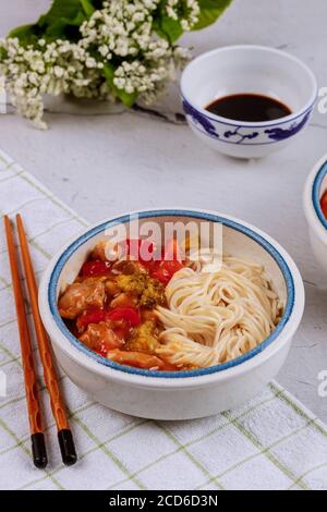 Chicken Teriyaki mit Paprika, Brokkoli und Nudeln in Schüssel mit Essstäbchen. Draufsicht. Stockfoto