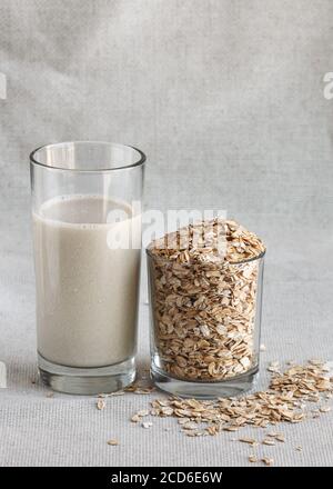 Gesunde Hafermilch im hohen Trinkglas mit Samen Stockfoto