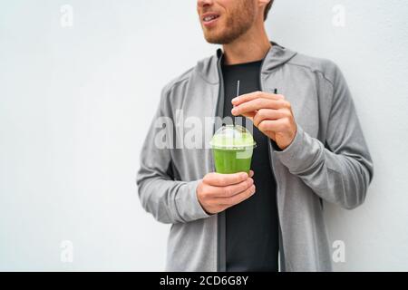 Gesunde junge Mann trinken grünen Saft Smoothie Tasse als Gewichtsverlust Detox Mahlzeit Ersatz Ernährung. Spinat Protein Shake für das Frühstück Stockfoto