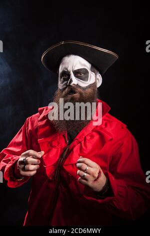 Mann mit langem Bart verkleidet wie mittelalterlicher Pirat auf schwarzem Hintergrund für halloween. Stockfoto