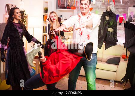 Gruppe von Freunden spielen Spiele während der Feier halloween in ihren Kostümen. Stockfoto