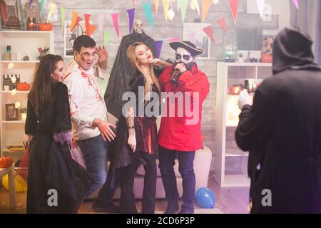 Rückansicht des grimmigen Reapers, der ein Foto von Monstern auf der halloween Party gemacht hat. Stockfoto