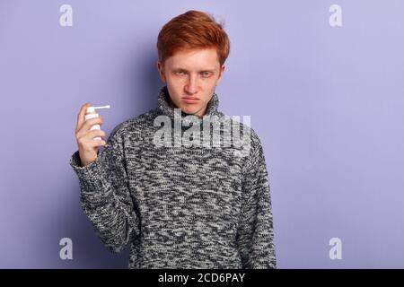 Wütend unglücklich depressiver junger Mann leidet an allergischer Reaktion, Nahaufnahme Porträt, isoliert blauen Hintergrund, Studio-Aufnahme Stockfoto