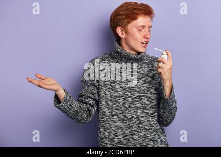 Junger Mann hat Kuschkälte. Nahaufnahme Seitenansicht Foto, isoliert blauen Hintergrund, Studio-Aufnahme Stockfoto