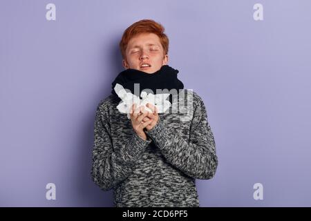 Mann mit geschlossenen Augen macht ein Heilmittel für die Erkältung, treatmnet. Mann behandelt sich zu Hause. Nahaufnahme Porträt, isoliert blauen Hintergrund Stockfoto