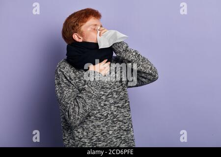 Ungesunde allergische Schüler niesen isoliert über blaue Wand. Close up Seitenansicht Porträt, isoliert blauen Hintergrund Stockfoto