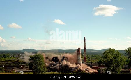 Der Einsturz eines Industrieschornsteins. Explosion eines alten Schornsteins einer veralteten metallurgischen Anlage. Stockfoto