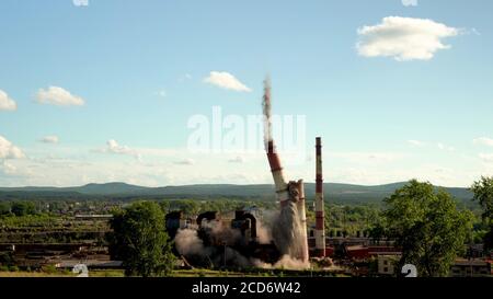 Der Einsturz eines Industrieschornsteins. Explosion eines alten Schornsteins einer veralteten metallurgischen Anlage. Stockfoto