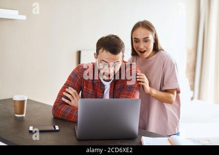 Emotive ziemlich junges Paar immer gute Nachrichten von den Eltern, überglücklich sein ausgezeichnete Nachricht, schauend schockiert und glücklich, indoor shot, Familienkonzept Stockfoto