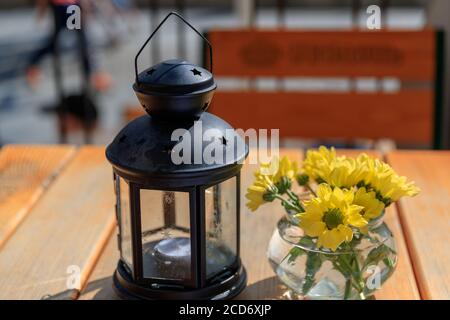 DANZIG, POLEN - 2017. AUGUST 24. Ostern gelbe Blumen und Kerzen Lampe auf dem Tisch. Stockfoto