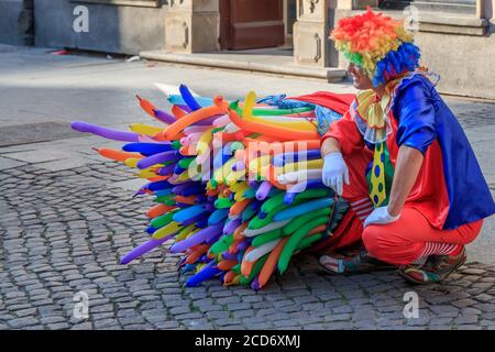 DANZIG, POLEN - 2017. AUGUST 24. Seitenansicht eines Clown Holding Ballons in der Straße. Stockfoto